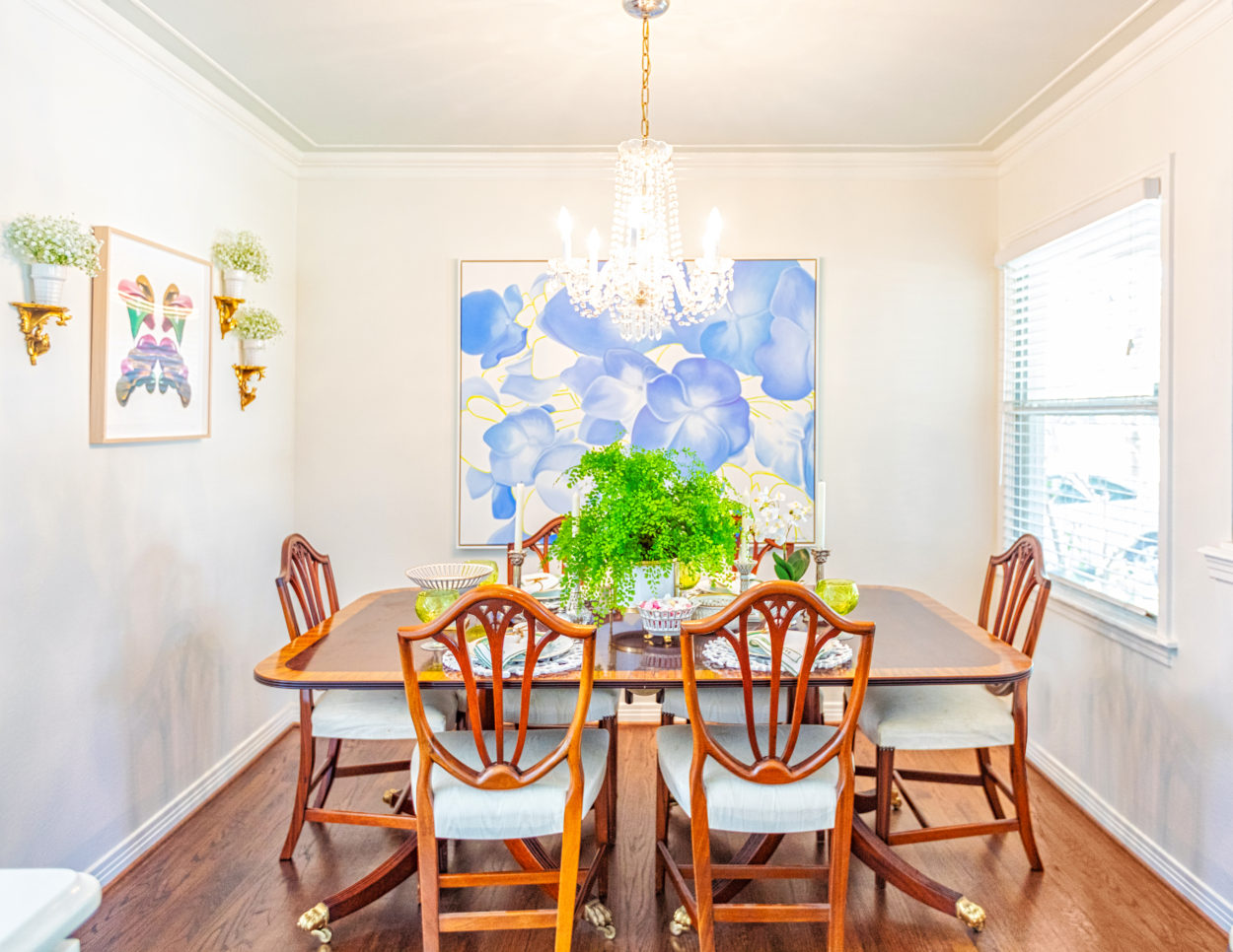 Susie Kwiatkowski's dining area with a blend of antiques and floral oil paintings.